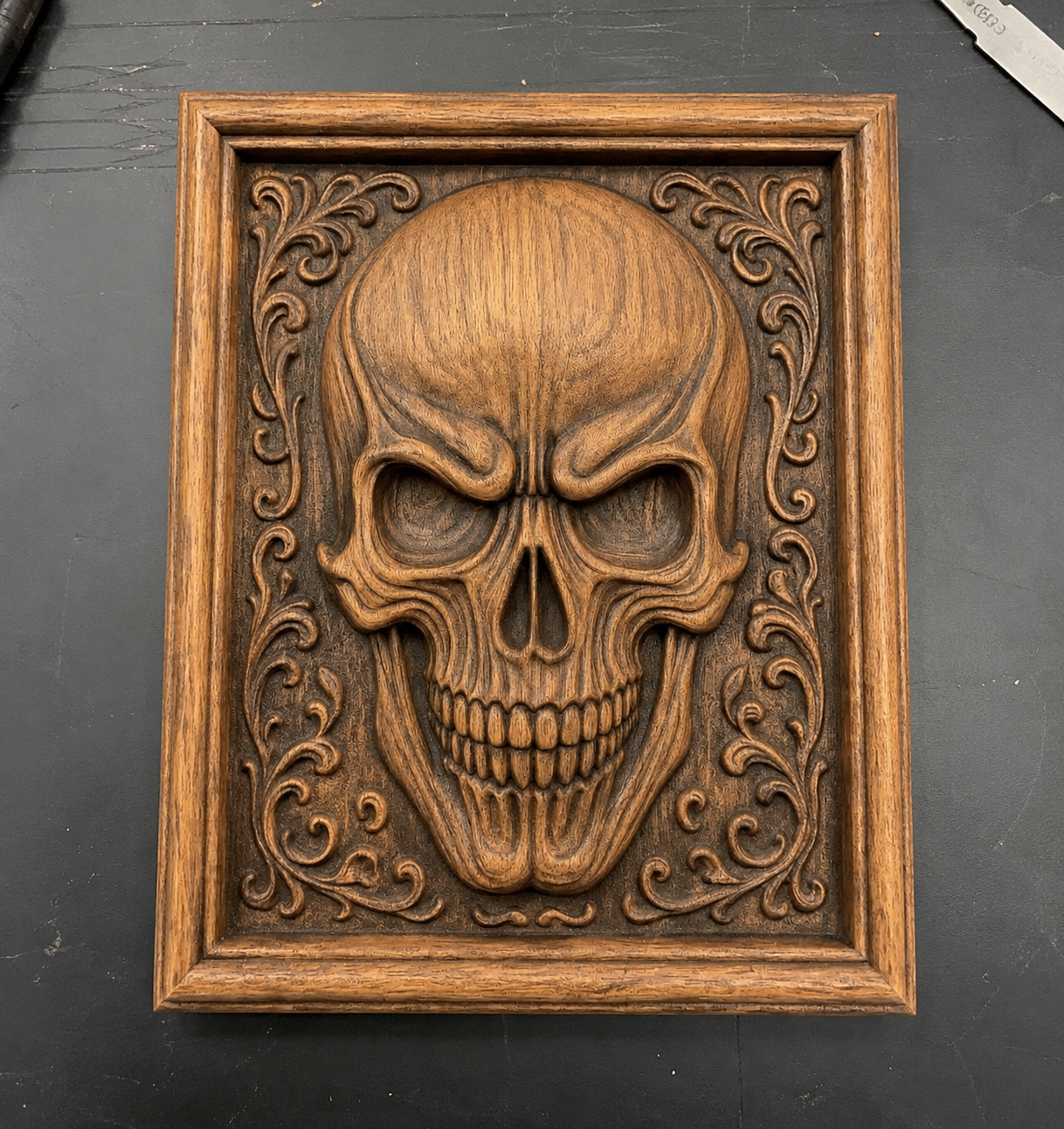 The Skull Relief 3-Pack CNC STL Bundle by Form Arcade features intricately carved skulls with ornate details in a rectangular frame. Perfect for woodworking or CNC carving projects, this gothic wall art adds a unique touch to your decor.