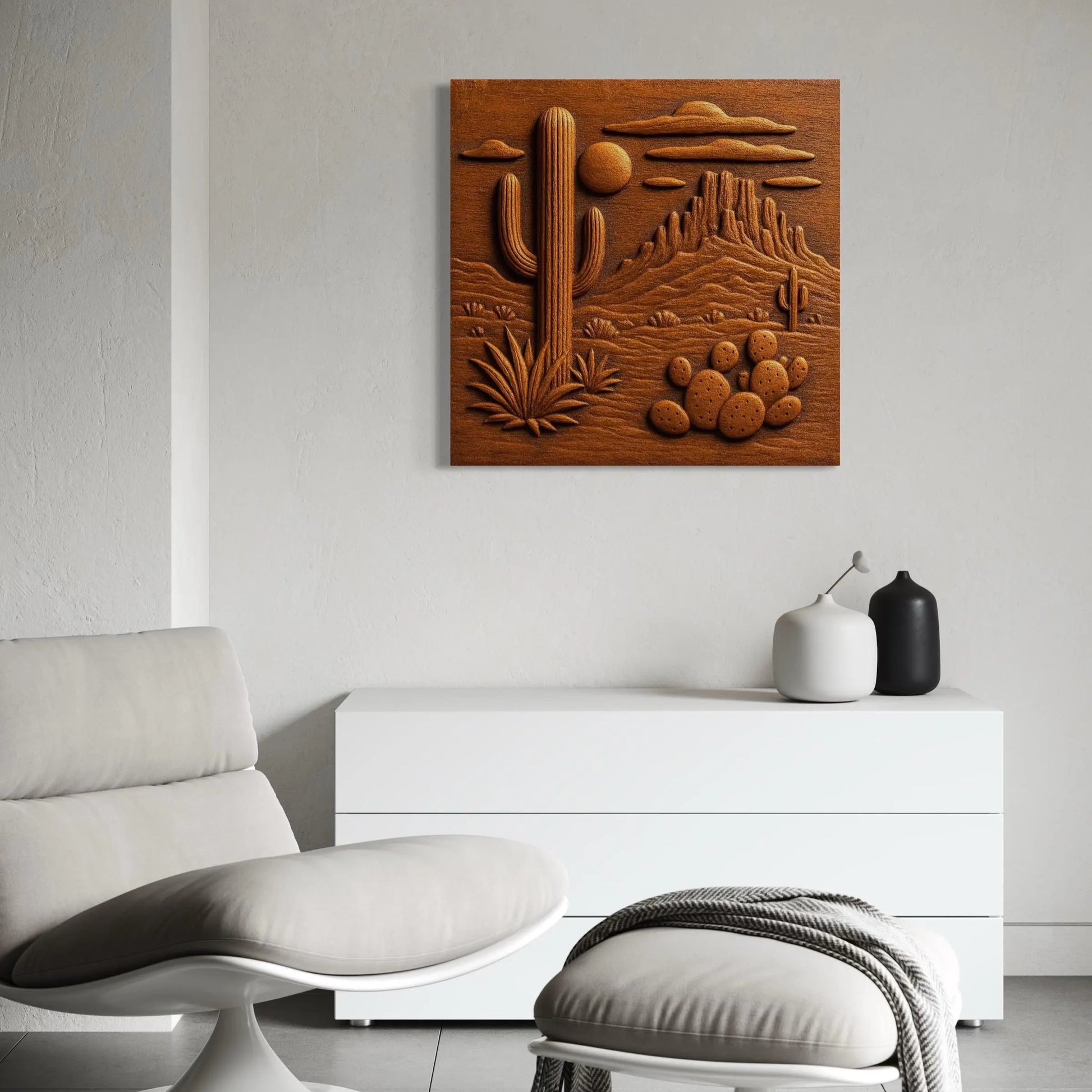 A modern, minimalist room with a white chair, ottoman, and cabinet displays Form Arcade's Desert Cactus CNC Relief STL File | Southwest CNC Wall Art featuring mountains and clouds, while two decorative vases sit atop the cabinet.