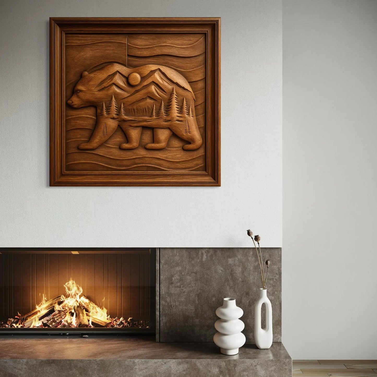 The "Mountain Bear Landscape Relief STL File" by Form Arcade, featuring a bear with mountain and forest design for CNC wall art, is displayed above a modern fireplace with two white vases on the gray mantel as the fire glows.